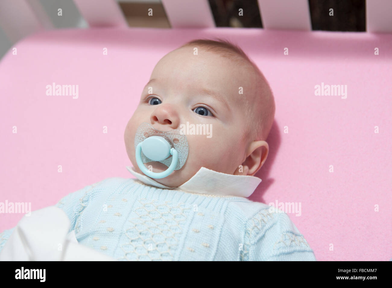 Wach viermonatigen Baby junge liegend im Bett mit Schnuller. Uphead Ansicht Stockfoto