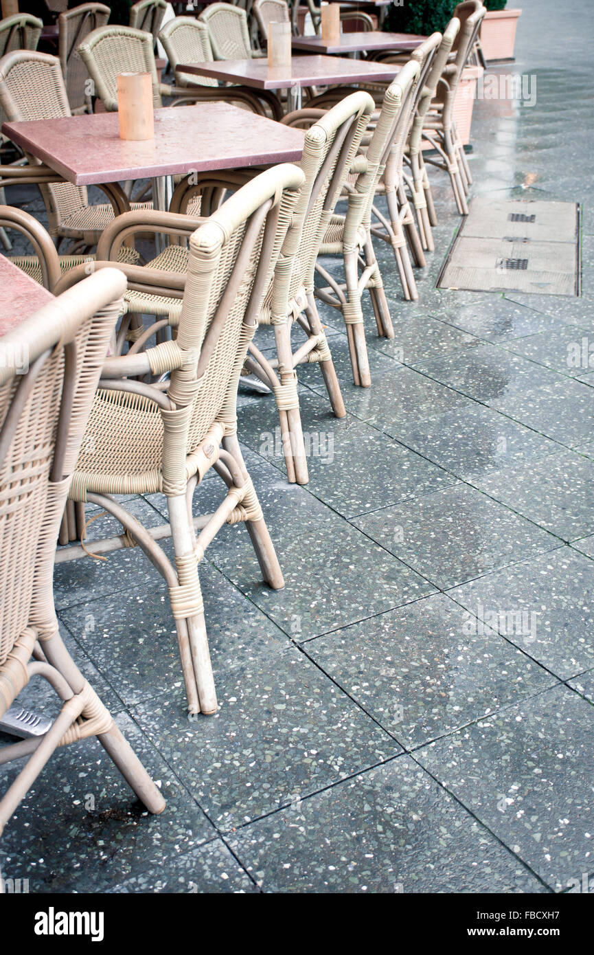 Eine Reihe von Tischen und Stühlen in einem Straßencafé Stockfoto