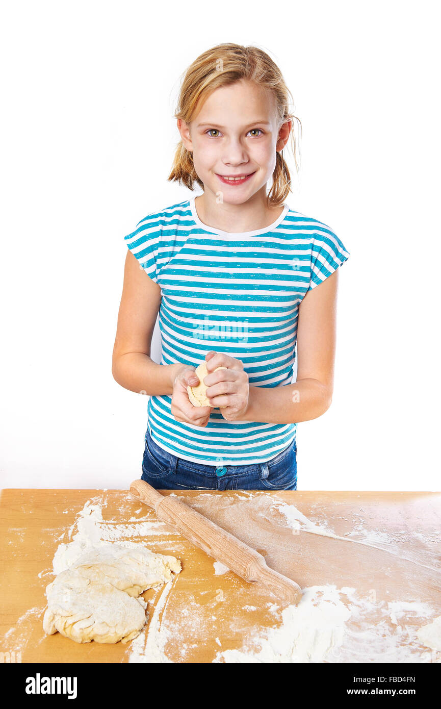 Mädchen knetet den Teig für den Kuchen auf dem Küchentisch isoliert Stockfoto