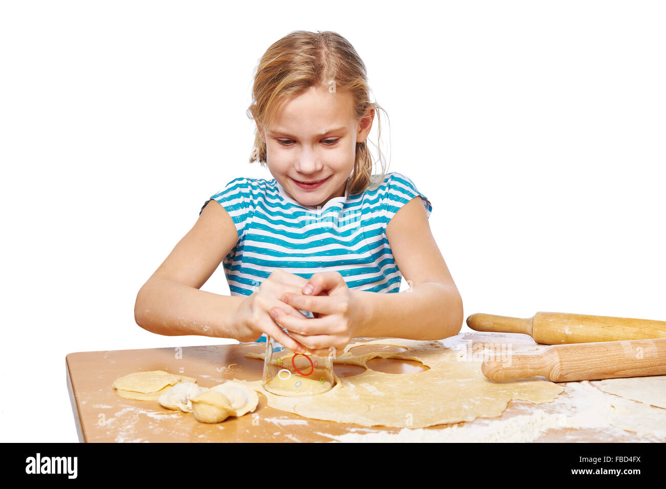 Mädchen knetet den Teig für Knödel auf dem Küchentisch isoliert Stockfoto