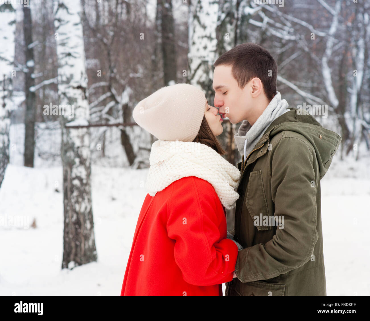 Glückliches junges Paar im Winter Park Spaß. Familie im Freien. Liebe Kuss Stockfoto