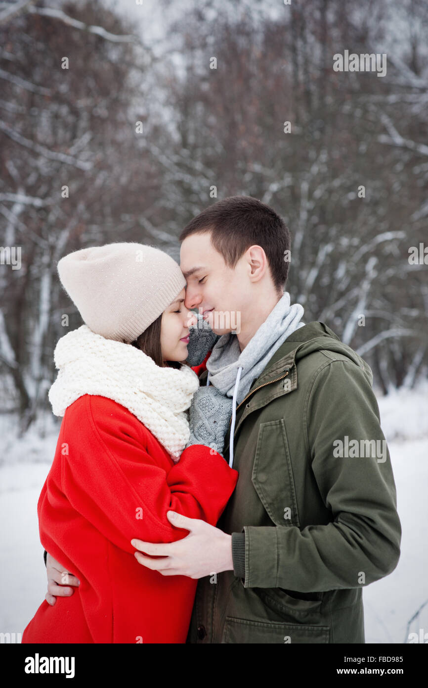 Glückliches junges Paar im Winter Park Spaß. Familie im Freien. Liebe Kuss Stockfoto