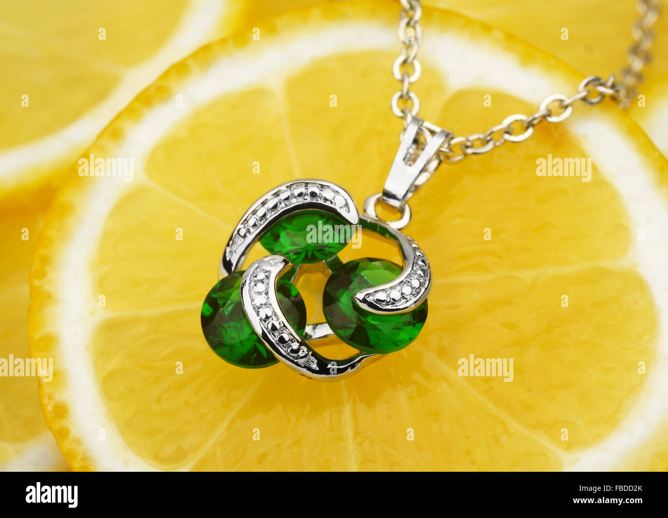 Schmuck-Anhänger mit Edelsteinen und Diamanten auf Zitrone Hintergrund Stockfoto