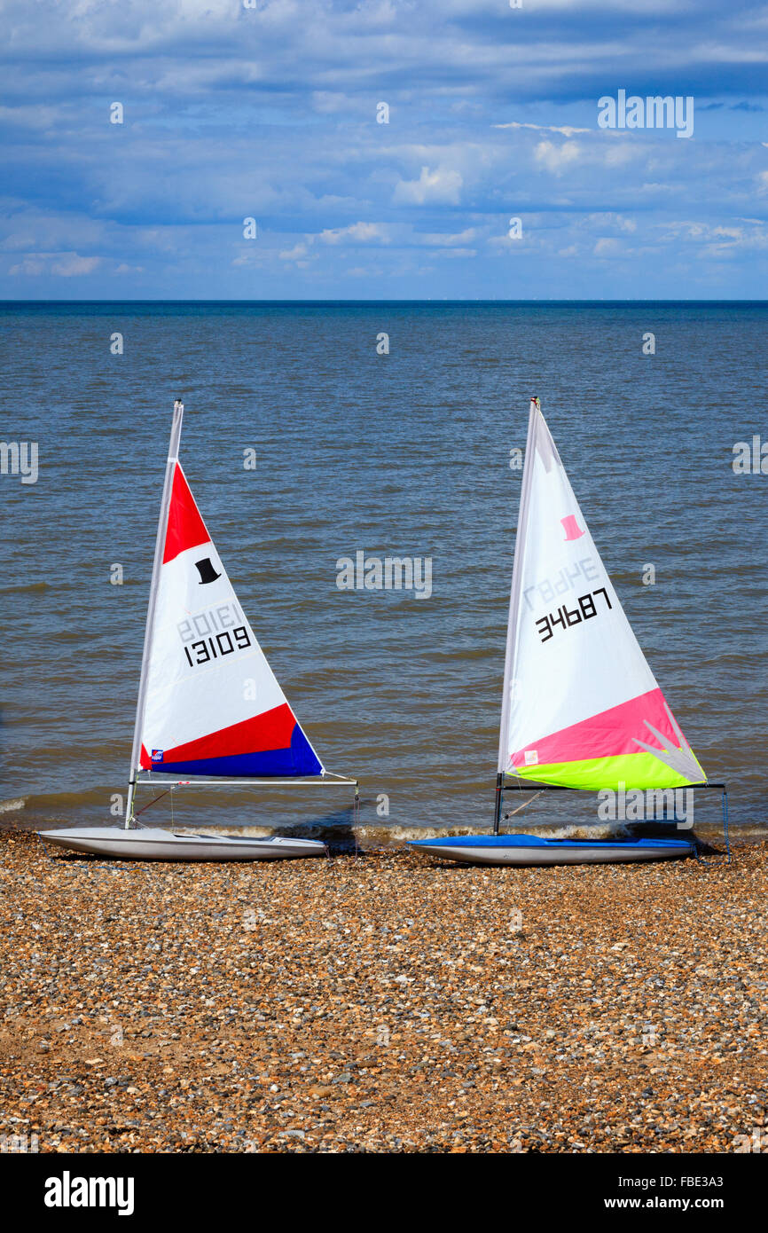 Unbesetzte Jollen am Wasser Rand in Herne Bay, Kent, England, an einem Sommernachmittag mit blauem Himmel und Meer, weiche Wolken. Stockfoto