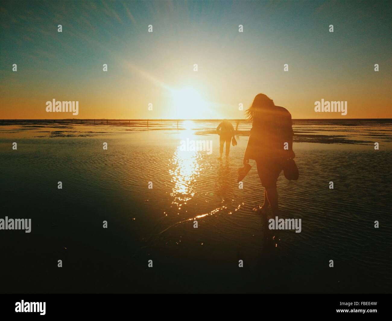 Silhouette Menschen zu Fuß am Strand bei Sonnenuntergang Stockfoto