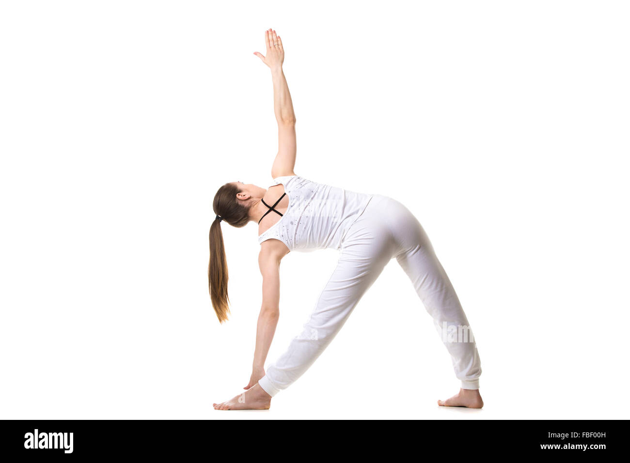 Schöne Fitness-Modell praktiziert Yoga oder Pilates, stehend im Dreieck-Yoga-Pose, Trikonasana, Dehnübungen, Rückansicht Stockfoto