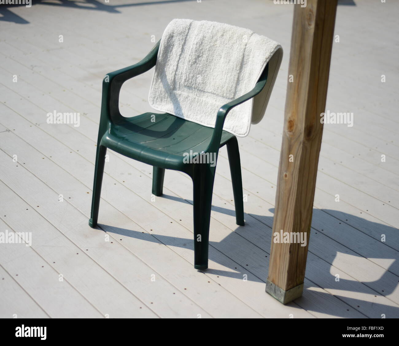 High Angle View Of Handtuch auf Kunststoff-Stuhl aus Holz auf dem Postweg Stockfoto