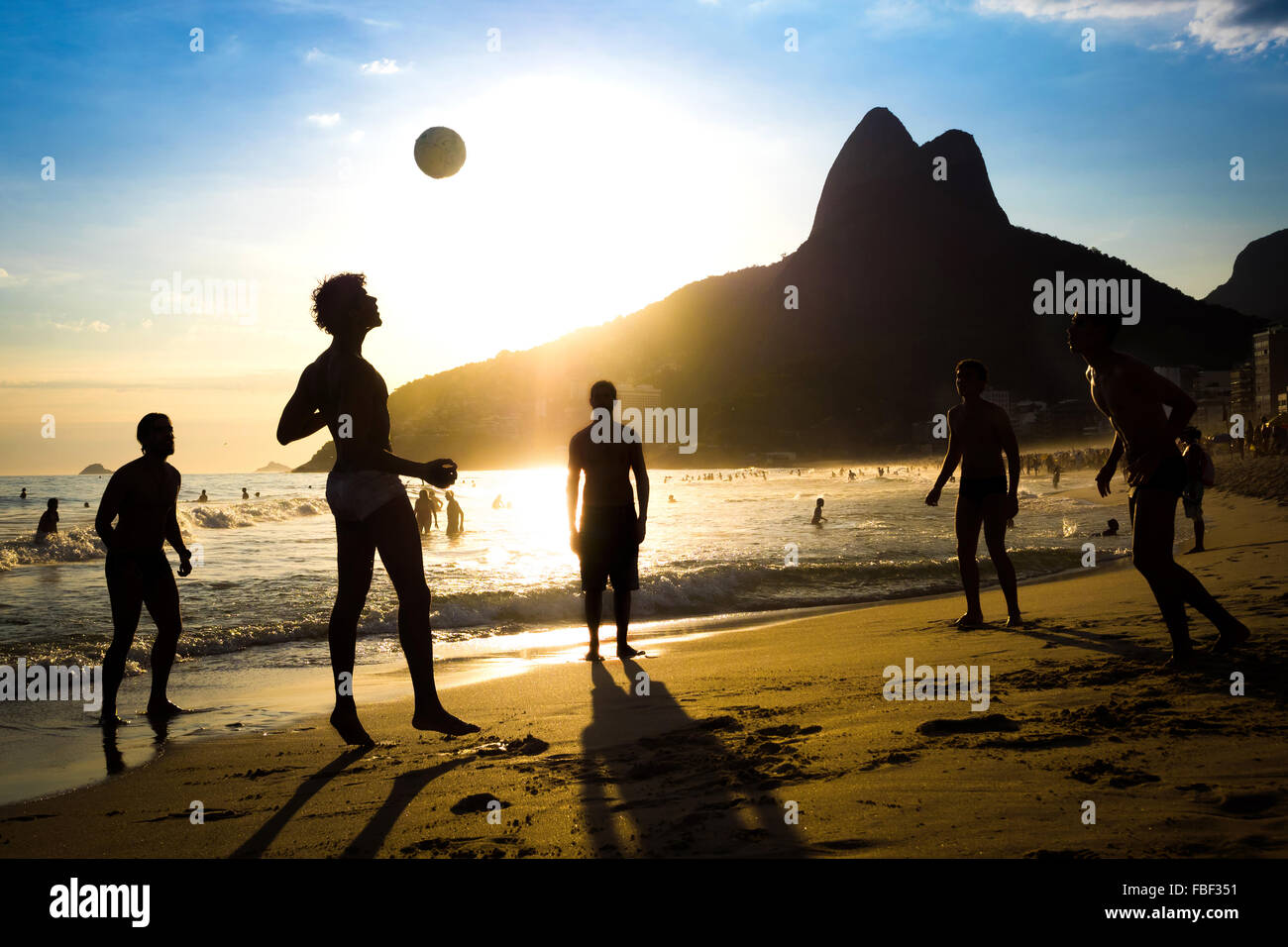 Rio de Janeiro, Brasilien, Silhouette der einheimischen Ball spielen bei Sonnenuntergang in Ipanema Strand. Stockfoto