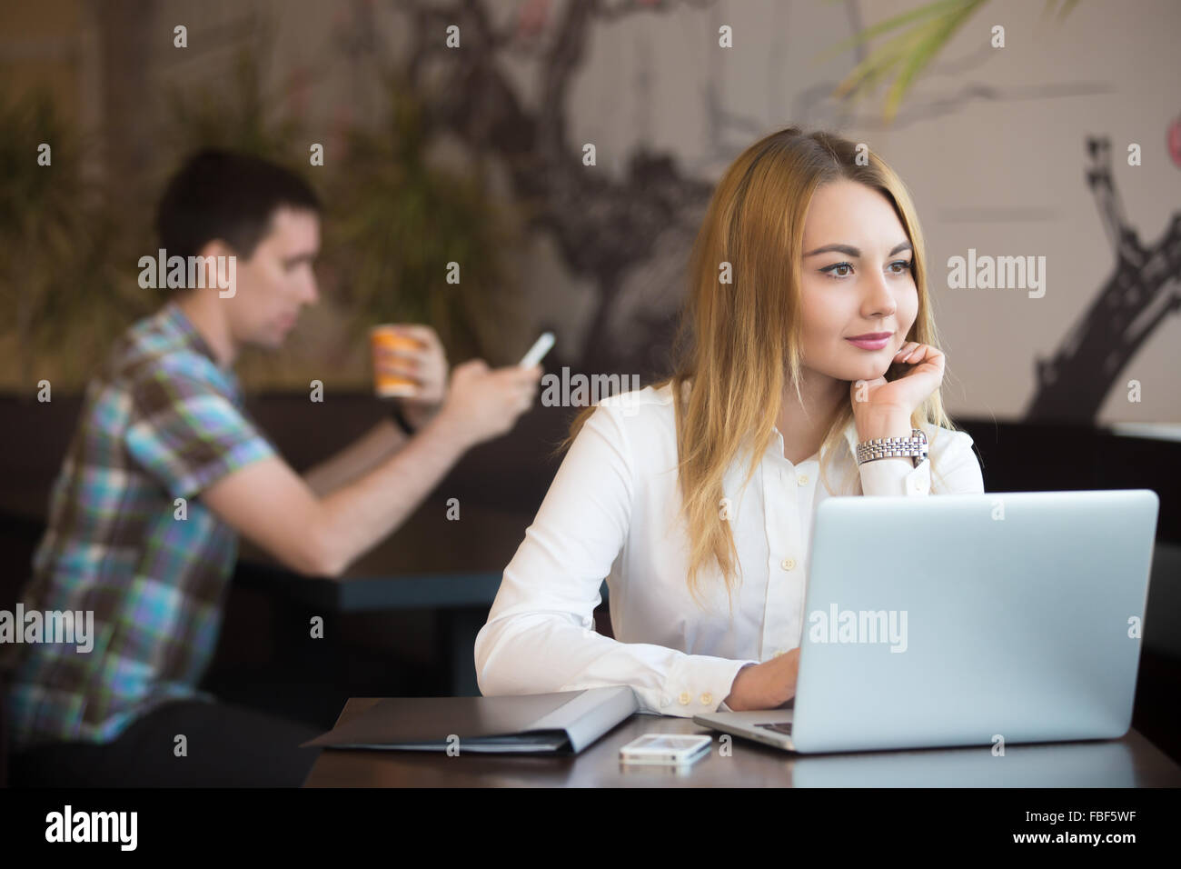 Junge schöne kaukasischen Geschäftsfrau im modernen Café sitzen arbeiten am Laptop, suchen Sie im Fenster mit Träumen Ausdruck, Stockfoto
