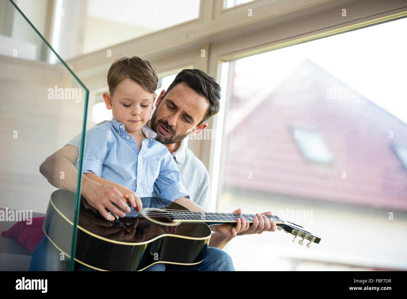 Vater Lehre Sohn, Gitarre zu spielen Stockfoto
