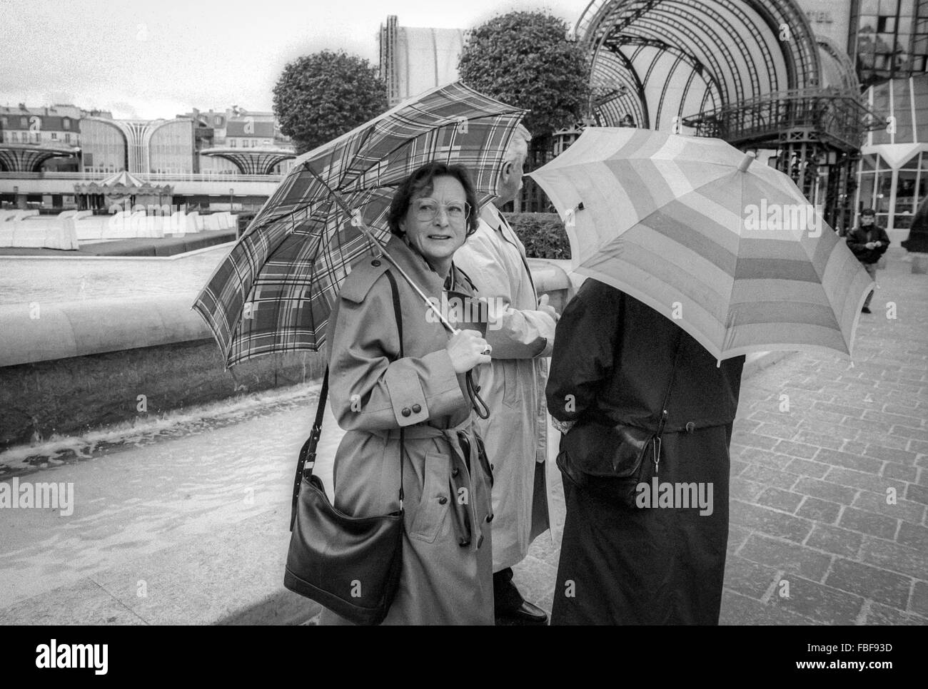 Damen mit Sonnenschirmen auf den Straßen von Paris in den 1990er Jahren. Stockfoto