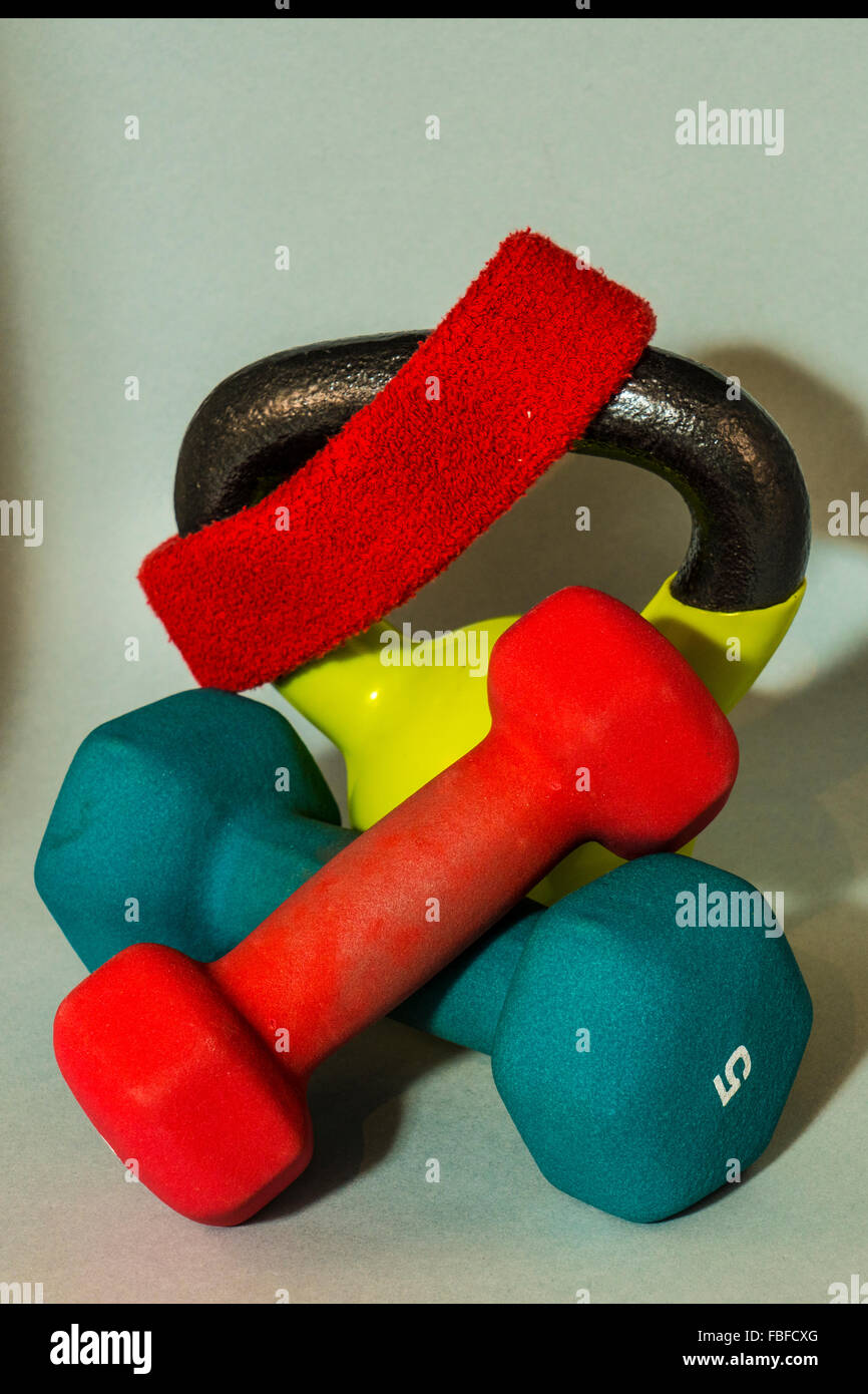 bunte gekreuzte Hanteln und Kettlebell mit roten Stirnband verwendet als freien Gewichten beim Krafttraining Stockfoto