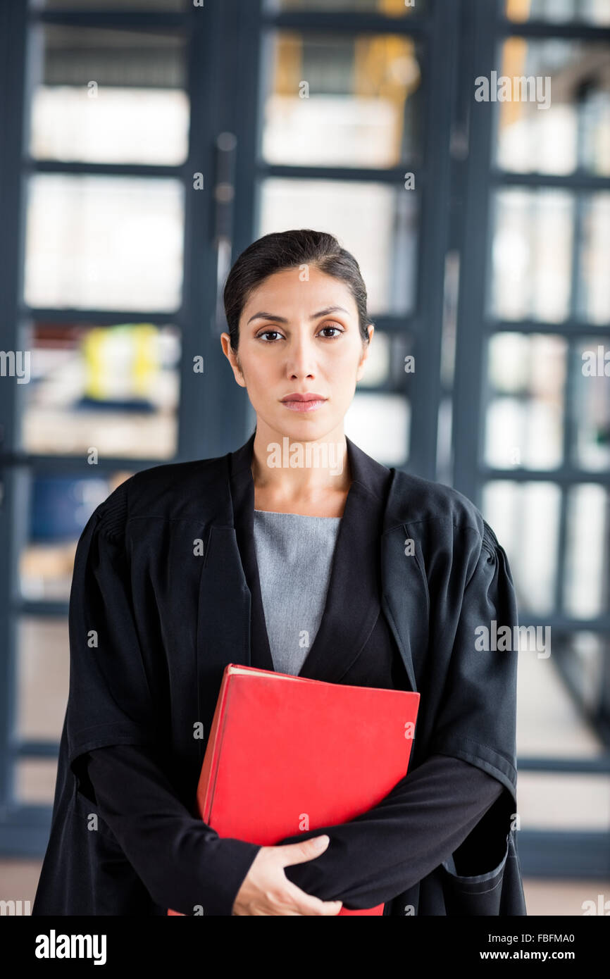 Weiblicher Rechtsanwalt hält ein rotes Buch Stockfoto