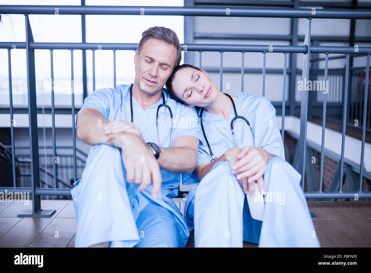Müde Ärzteteam Einschlafen auf Etage Stockfoto