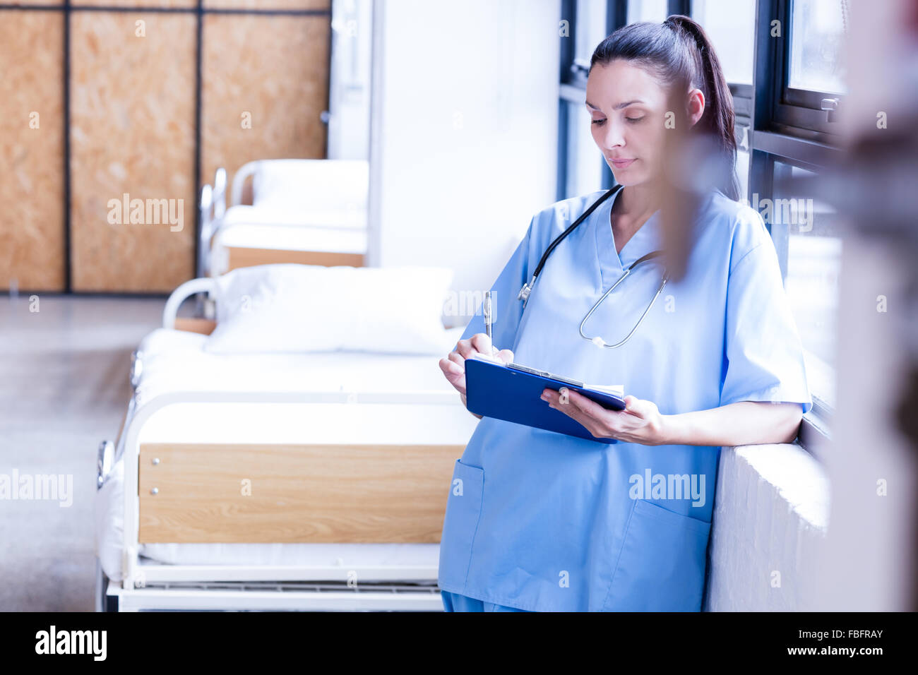 Ernsthafte Krankenschwester hält Bericht über die Zwischenablage Stockfoto
