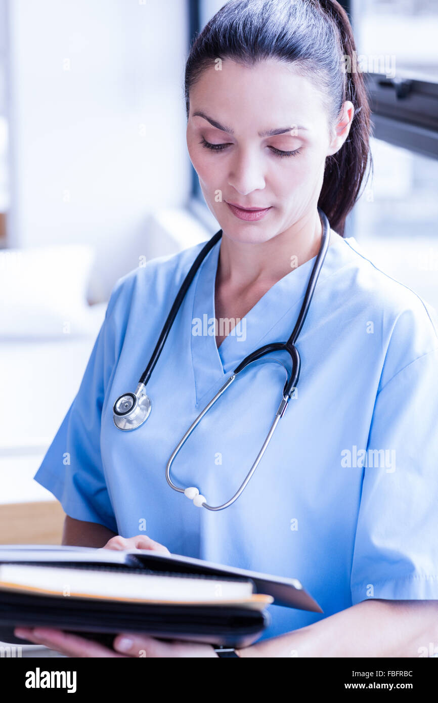 Ernsthafte Krankenschwester hält Bericht über die Zwischenablage Stockfoto