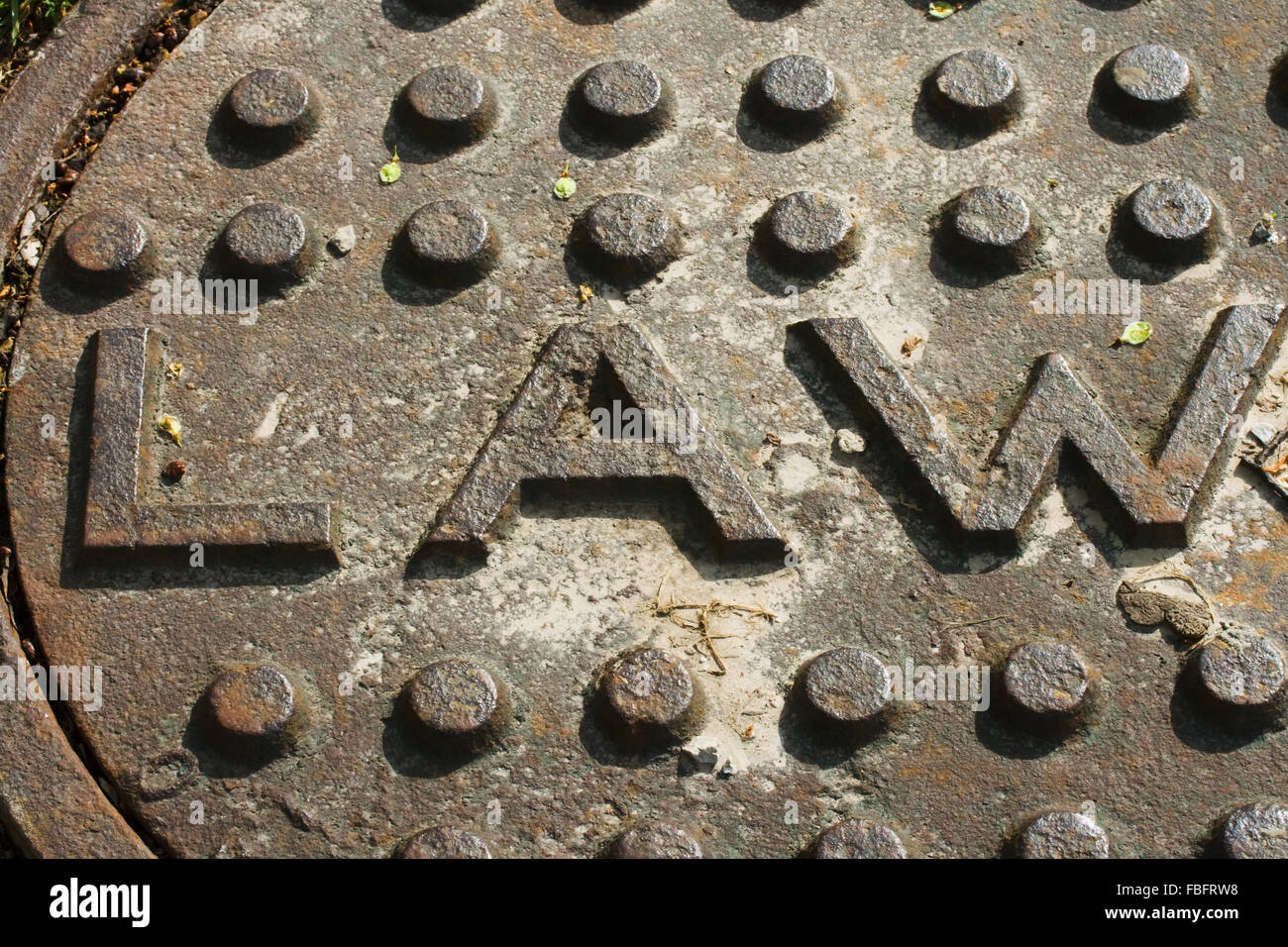 Kanaldeckel mit den Buchstaben rechts Stockfoto