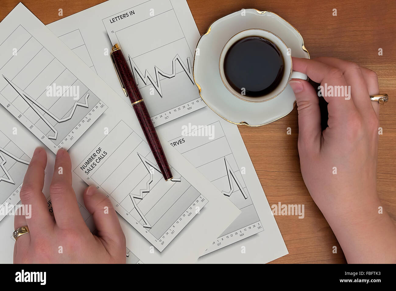 Büro-Papiere. Frau Hände Arbeit im Büro mit Grafiken von Papier und einen Stift und Kaffee trinken. Stockfoto