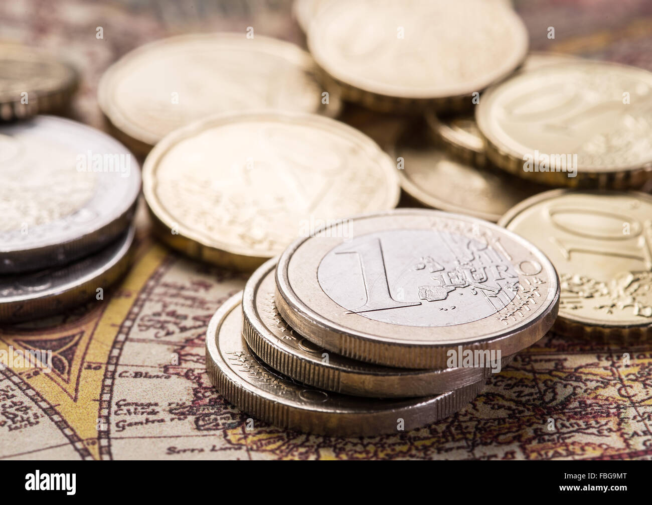 Euro-Münzen über die alte Weltkarte. Makro-Bild. Stockfoto