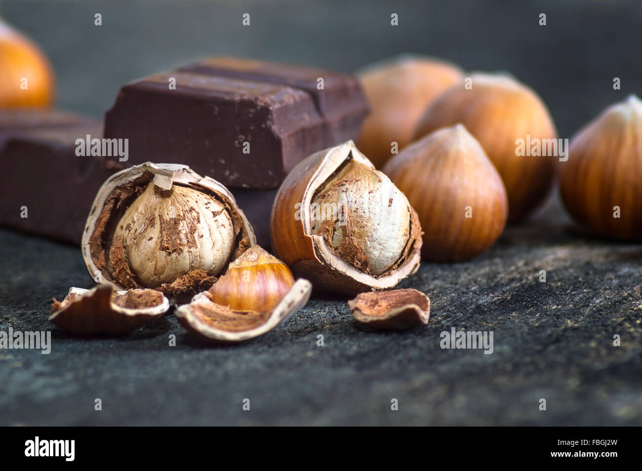 Schließen Sie sich frische braune Haselnuss auf Holztisch mit Schokolade. Selektiven Fokus. Stockfoto