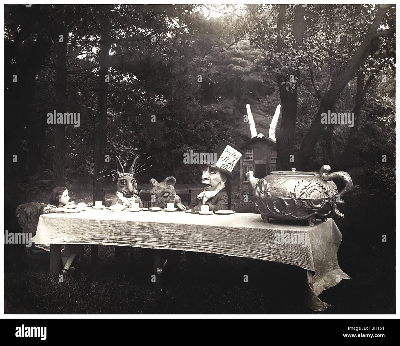 "The Mad Hatter Tea party" Szene von 1915 Stummfilm-Adaption von "Alice im Wunderland" von Lewis Carroll, Regie: W. Young. Das Foto zeigt von links nach rechts: Viola Savoy als Alice, Herbert Rice als das weiße Kaninchen, Louis Merkle als das Murmelthier und William Tilden als Mad Hatter. Siehe Beschreibung für mehr Informationen. Stockfoto