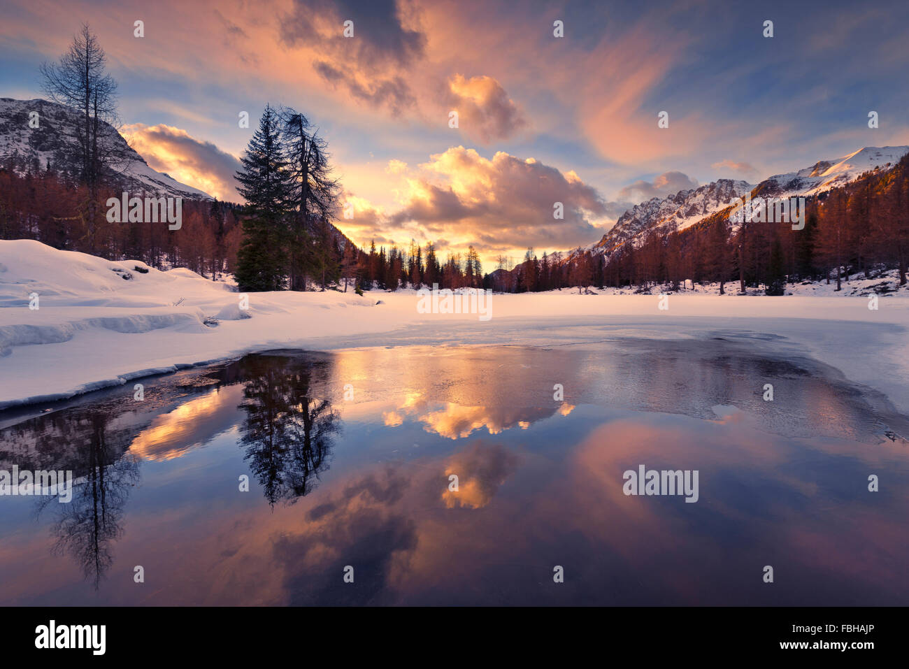 Italien, Dolomiten, Südtirol, Lago San Pellegrino, Winter, Schnee, Eis, Wolken, Reflexion, Bäume, Berge, Holz, Himmel, episch, Traum, Paradies, Leuchten, Licht, Sonnenuntergang, Farben, gefroren, See, Panorama, Landschaft Stockfoto