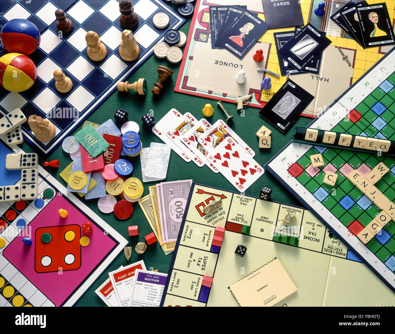 Stillleben Auswahl an Brettspielen (Monopoly, Schach, Cluedo, Scrabble) mit Spielkarten und Chips Glücksspiel Stockfoto