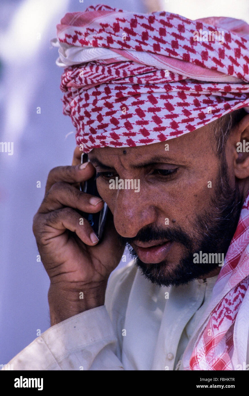 Mudhaireb (Mudayrib), Oman.  Mittleren Alters omanischen Mann sprechen auf seinem Handy. Stockfoto