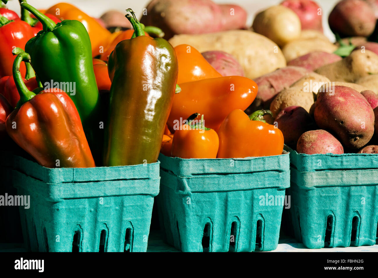 Paprika, rotbraune und rote Kartoffeln, verpackt auf einem Bauern-Markt zu verkaufen. Stockfoto