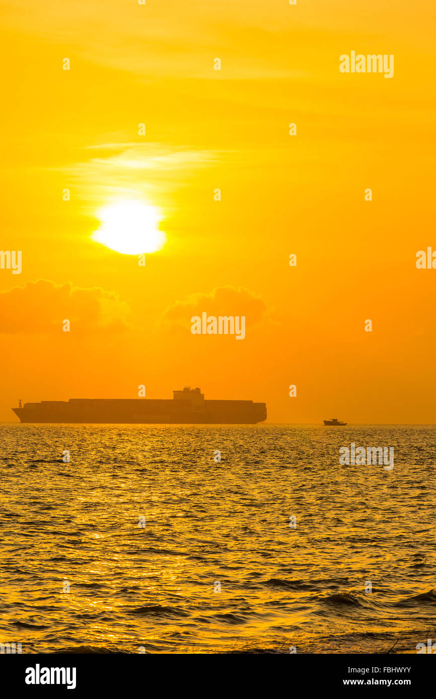 Frachtschiff am Meer bei Sonnenuntergang Stockfoto