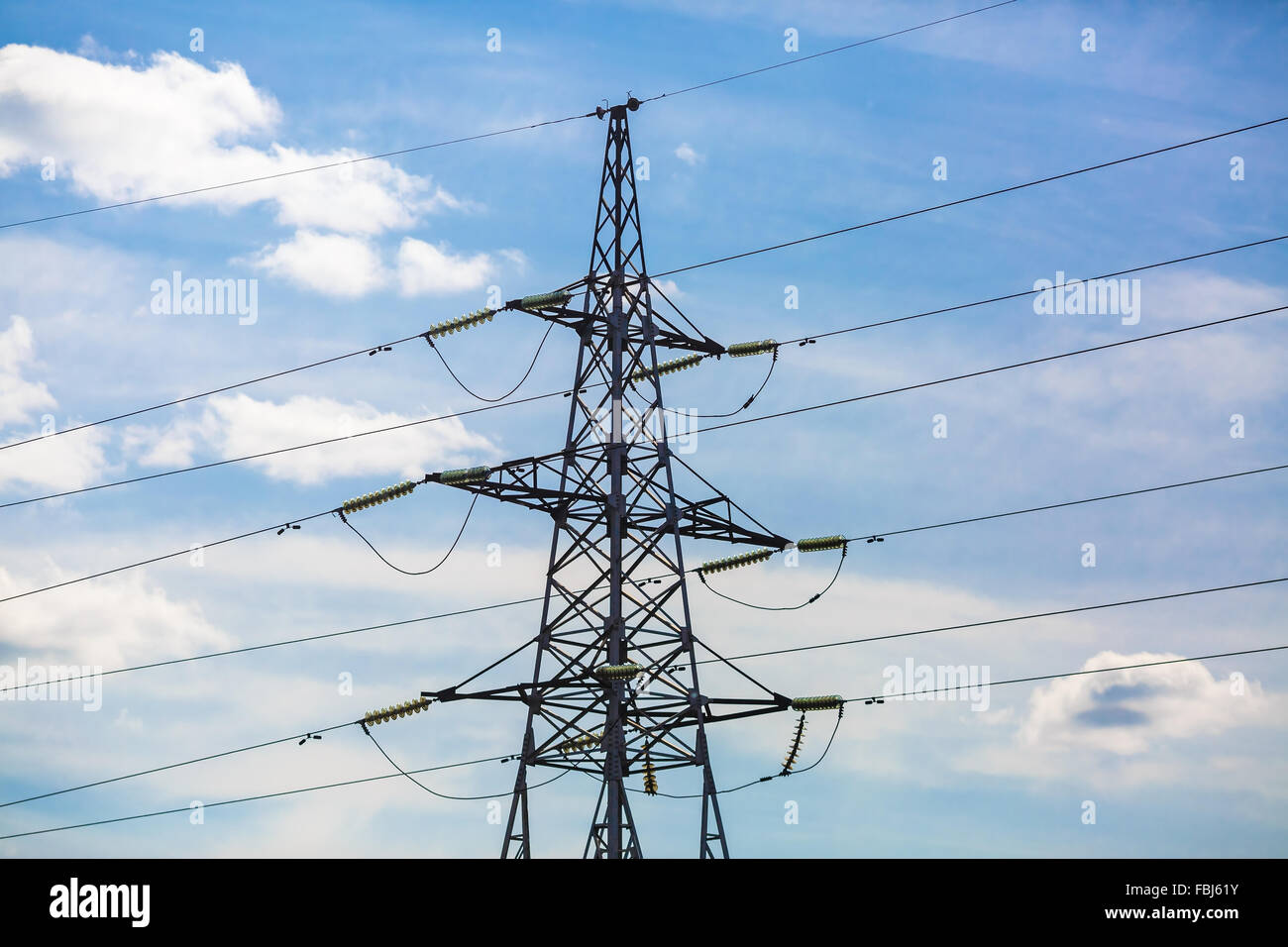 Strommast vor blauem Himmelshintergrund abhebt. Hochspannungs-Turm. Stockfoto