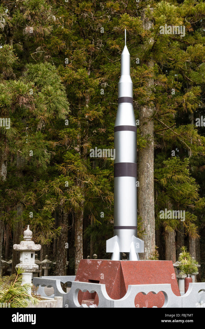 Japan, Koyasan, Okunoin Friedhof. Grabstein Denkmal in Form eines Apollo Mond Rakete mit Zeder Wald als Hintergrund. Stockfoto