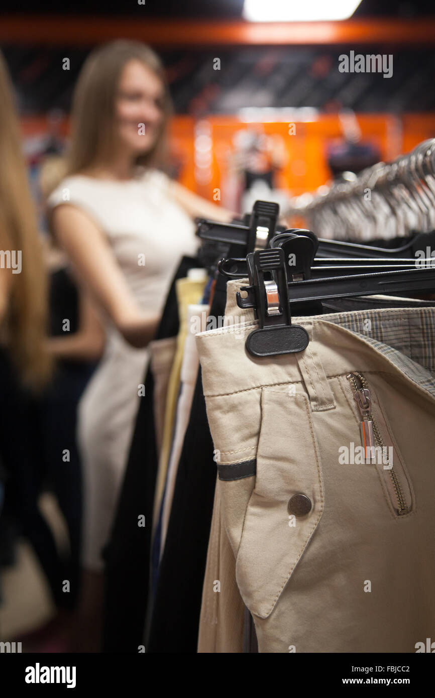 Nahaufnahme von Hosen auf Kleiderbügeln in der Fashion Mall, geringe  Schärfentiefe, verschwommene junge schöne lässige Frau Wahl Kleidung  Stockfotografie - Alamy