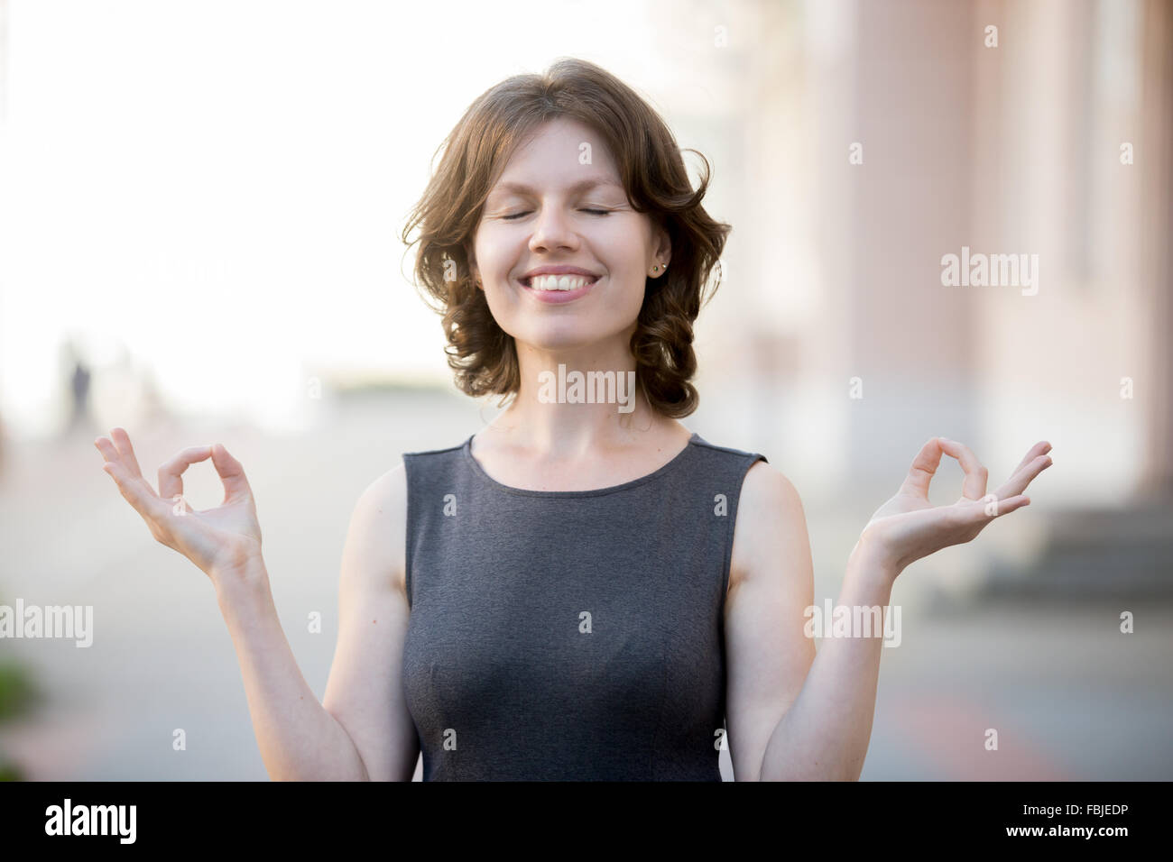 Porträt von glücklich schöne Büro Frau meditieren in städtischen Straße im Sommer, smart casual Geschäftsfrau üben Yoga gro Stockfoto