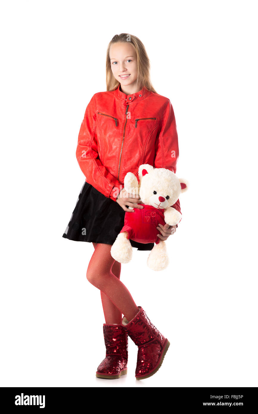 Portrait von glücklich schön lässig Teenager-Mädchen in rotem Lederjacke hält Teddybär, freundlich lächelnd, Blick in die Kamera Stockfoto