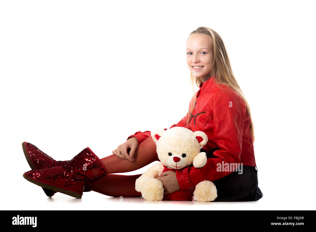 Porträt von glücklich schön lässig Teenager-Mädchen in rote Lederjacke sitzen mit Teddybär, freundlich lächelnd, kam zu betrachten Stockfoto