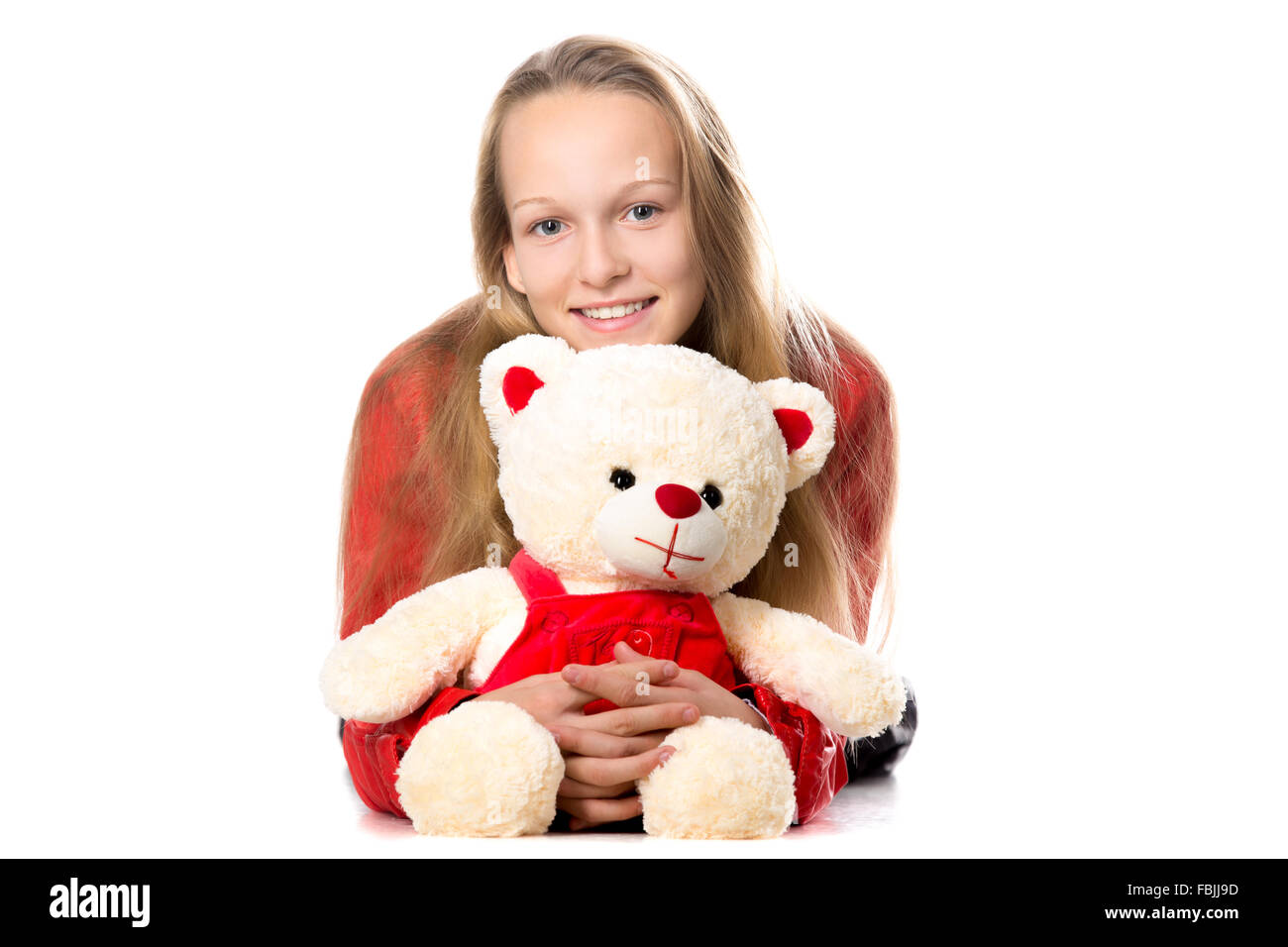 Portrait von glücklich schön lässig Teenager-Mädchen in rotem Lederjacke umarmen Teddybär, freundlich lächelnd, Blick in die Kamera Stockfoto