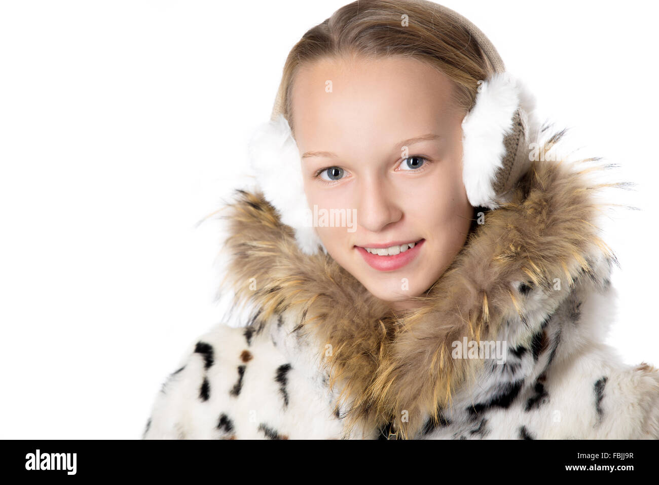 Kopfschuss-Porträt von glücklich lustig schön lässig Teenager-Mädchen tragen Wintermantel und Ohrenschützer, Blick in die Kamera mit fröhlich Stockfoto