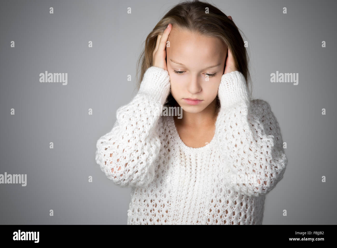 Porträt von unglücklich schönen casual kaukasische Mädchen tragen weiße gestrickten Pullover, hielt ihren Kopf in Armen mit depressiven Stockfoto