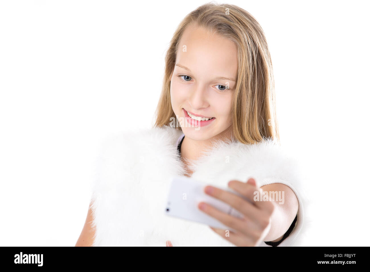 Glücklich niedlich schöne kaukasischen blonde Mädchen in weißen pelzigen Outfit nehmen Selfie mit Smartphone, posieren für Selbstporträt Stockfoto