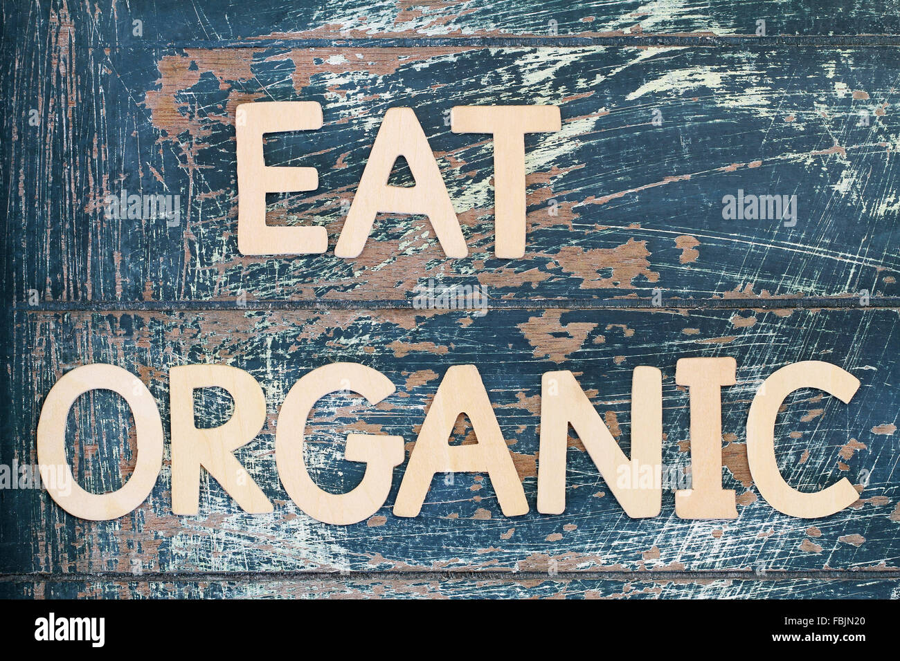 Essen Sie Bio mit Holzbuchstaben auf rustikale Oberfläche geschrieben Stockfoto
