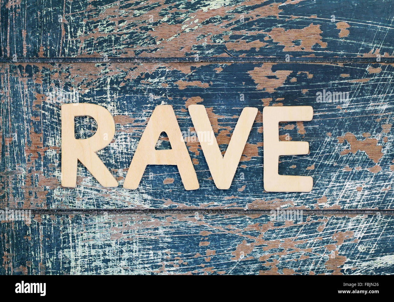 Wort-Rave mit Holzbuchstaben auf rustikale Oberfläche geschrieben Stockfoto