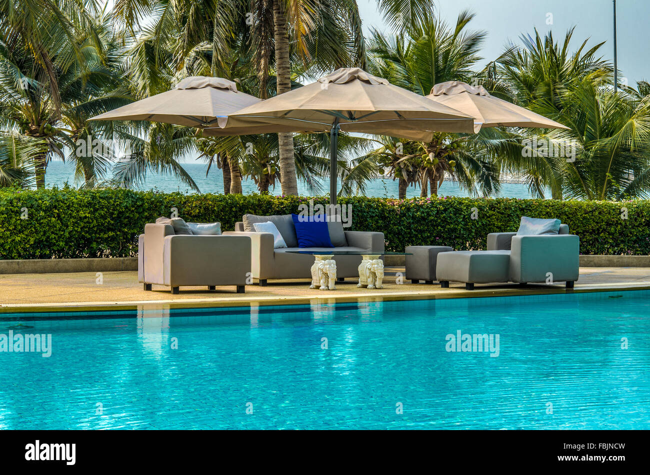 Outdoor-Sofa mit Kissen und Kissen im Garten am Pool Stockfoto