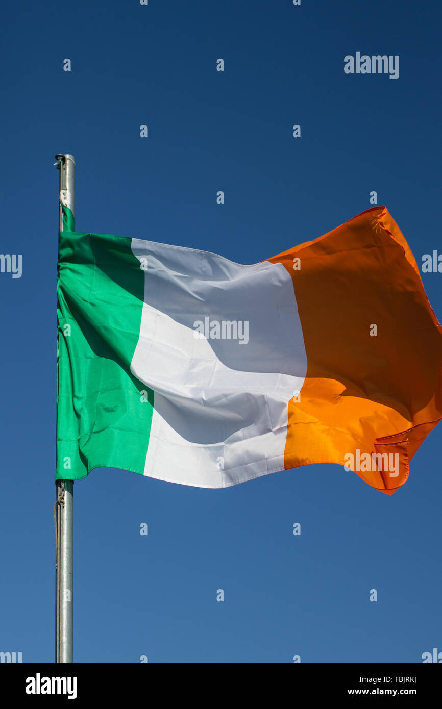 Teh irische Trikolore fliegt auf weißen Pol in County Armagh, Irland. Die Nationalflagge von Irland. Grüne, weiße & Orange. Stockfoto