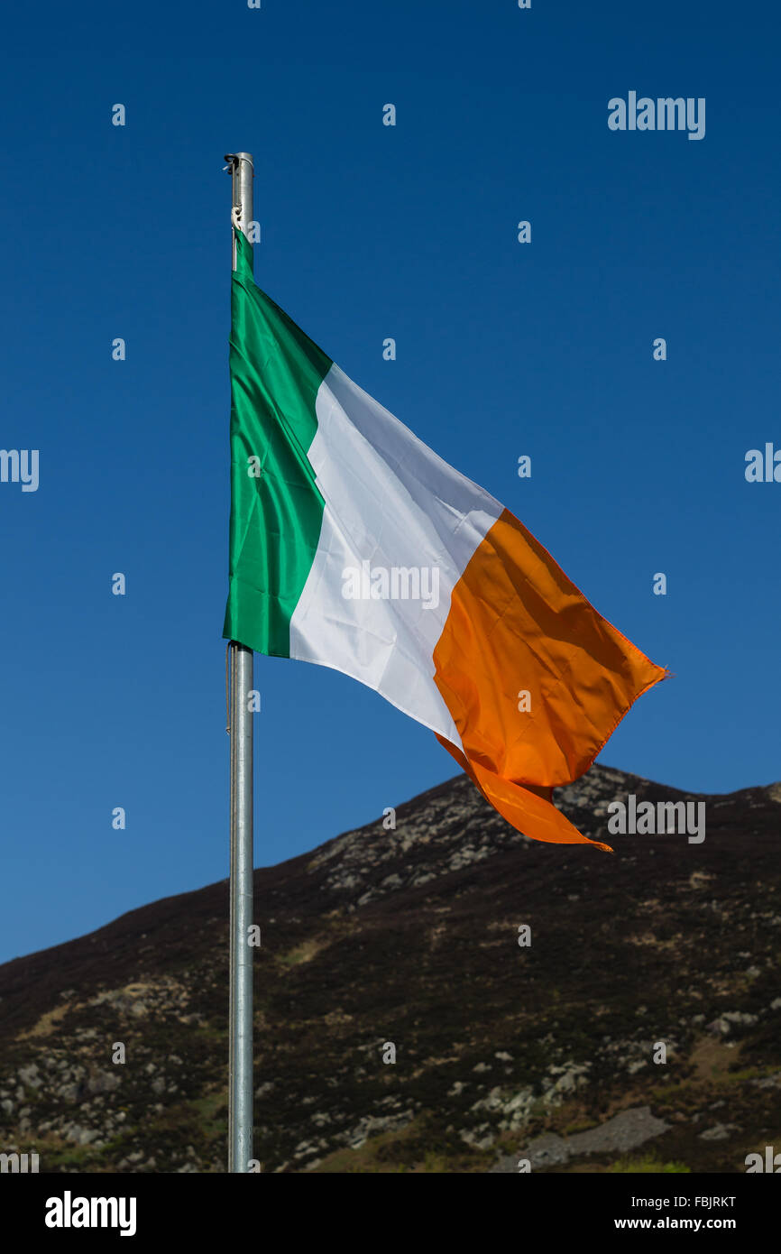 Die irische Trikolore fliegt auf weißen Pol in County Armagh, Irland. Die Nationalflagge von Irland. Grüne, weiße & Orange. Stockfoto