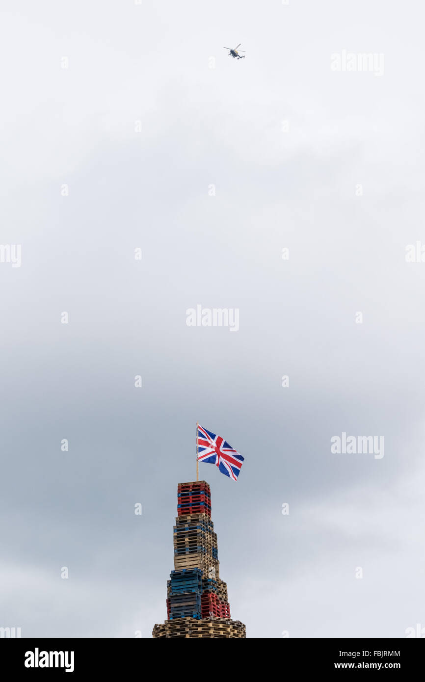 Ein Polizei-Hubschrauber fliegt über ein Loyalist Lagerfeuer in Belfast Stockfoto