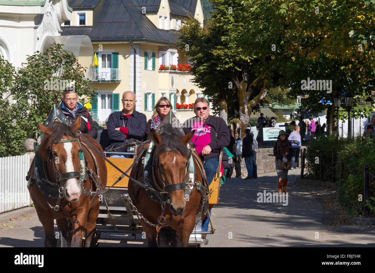 Touristen, die Fahrt in einer Pferdekutsche im Dorf Hohenschwangau, Deutschland Stockfoto