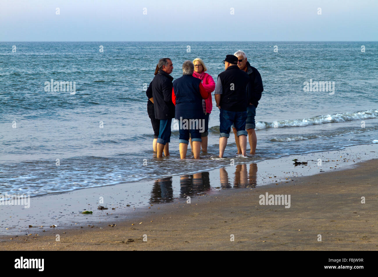 Eine Gruppe von Männern und Frauen waten im Wasser an einem Strand auf Römö Insel in Jütland, Dänemark. Stockfoto