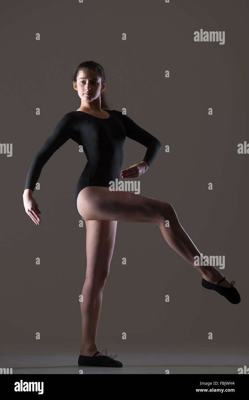 Porträt von schöne junge Tänzerin Frau in schwarzen Sportbekleidung, Sport, tanzen, Ganzkörperansicht, Studio, dunkler Hintergrund Stockfoto