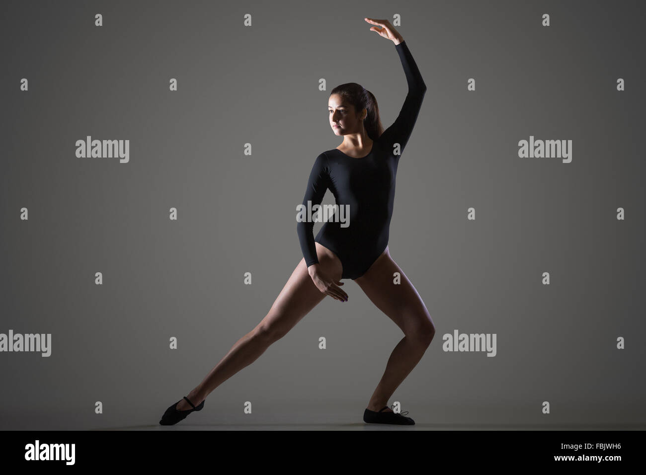 Porträt von attraktiven jungen Tänzer Frau in schwarzen Sportbekleidung, Sport, tanzen, Ganzkörperansicht, Studio, dunklen Hintergrund Stockfoto